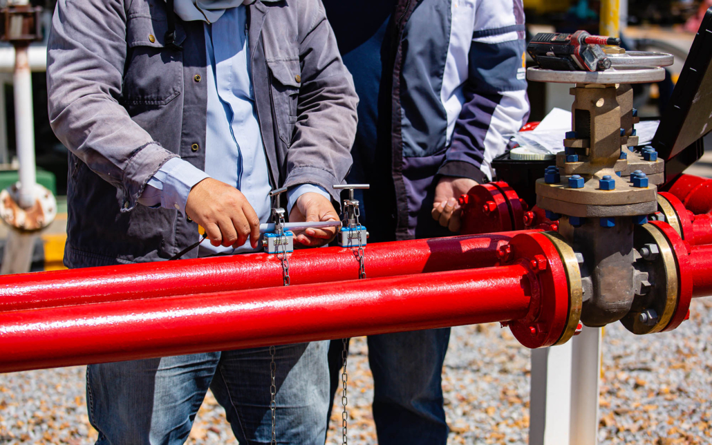 Two workers looking over outdoor fire pipe