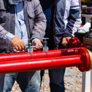 Two workers looking over outdoor fire pipe