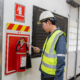 Electrical engineer inspecting fire extinguisher
