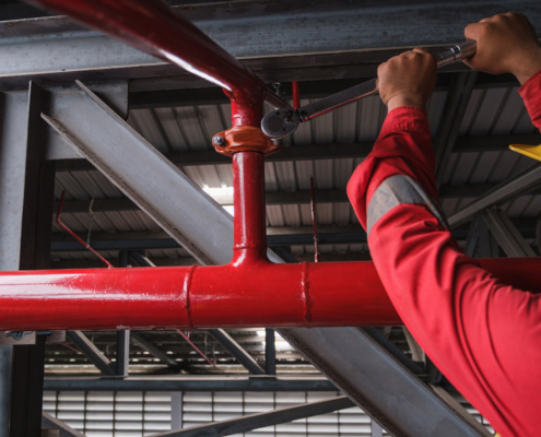 worker installing fire sprinkler pipe system