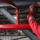 worker installing fire sprinkler pipe system